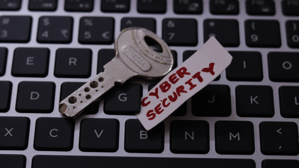 Sicherheitsschlüssel auf Tastatur mit einem Zettel auf dem Cyber Security steht