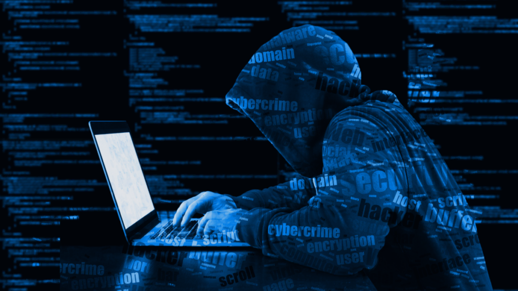 Klassische Darstellung eines Hackers mit Kapuze, welcher vor seinem Rechner sitzt